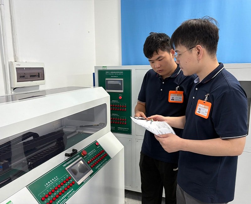Hulk Cable laboratory technicians conducting performance testing and data recording on precision cable testing equipment, emphasizing R&D rigor and quality validation for industrial-grade cables