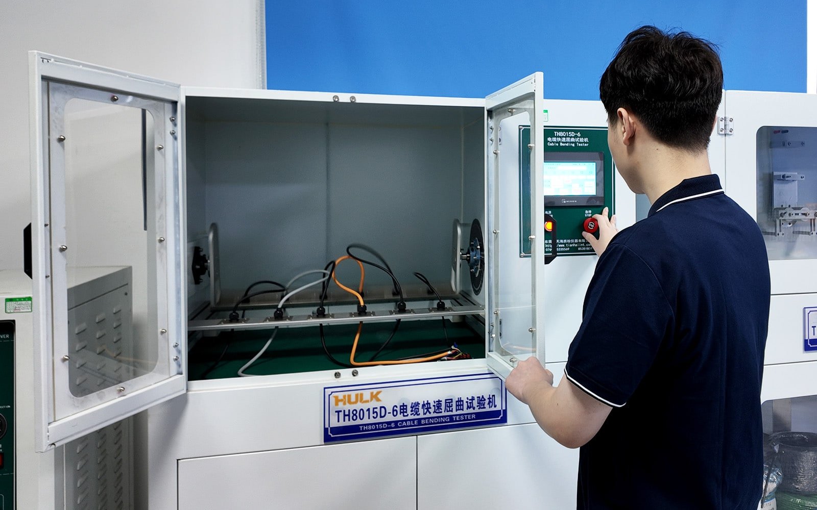 Hulk Cable TH8015D-6 Cable Bending Tester with engineer operating control panel, testing multiple colored cables under high-frequency rapid bending to validate fatigue resistance for dynamic applications