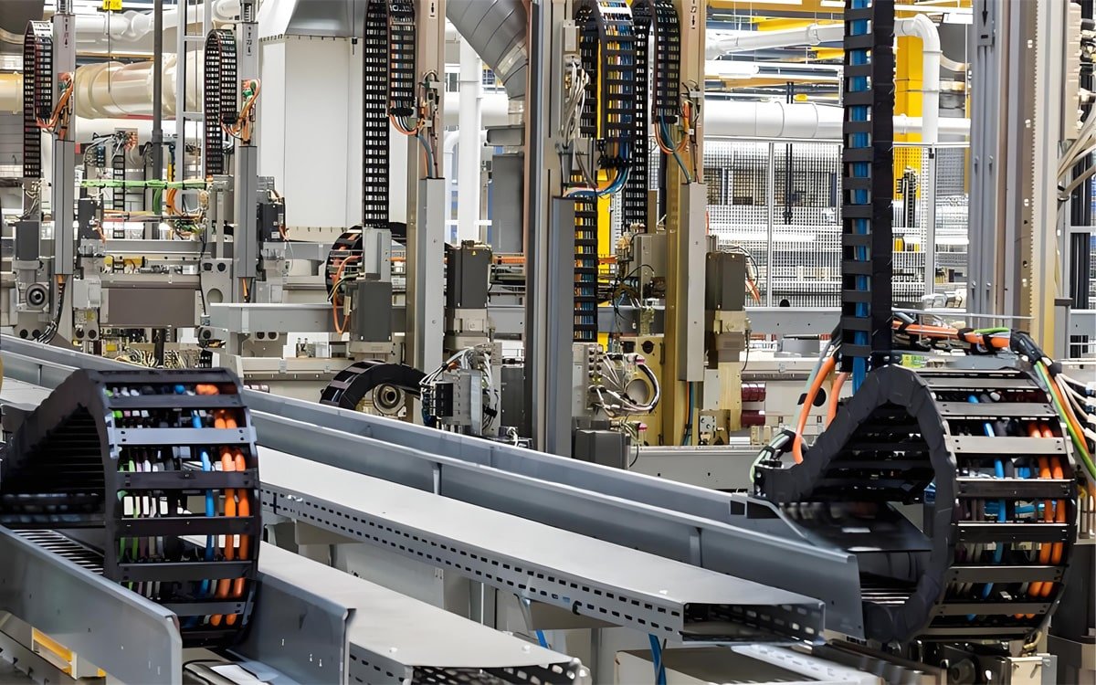 Hulk Cable intelligent drag chain system integrated in automated production line, protecting multi-colored cables and pneumatic tubes with silent high-speed movement for industrial robotics and CNC machinery