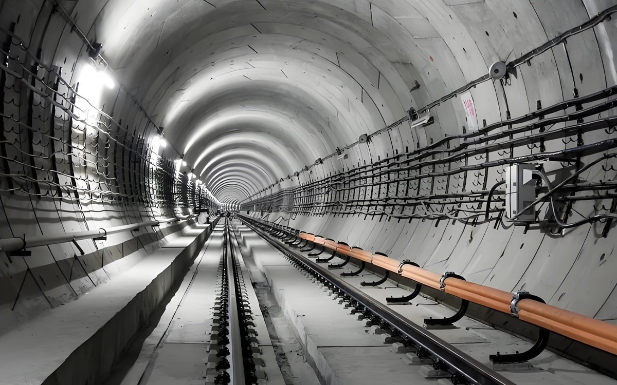 Hulk Cable high-reliability power and signal cabling solution for subway tunnel rail transit system, featuring black and orange cables mounted along tunnel walls with metal brackets for stable transmission under high vibration, humidity, and electromagnetic interference