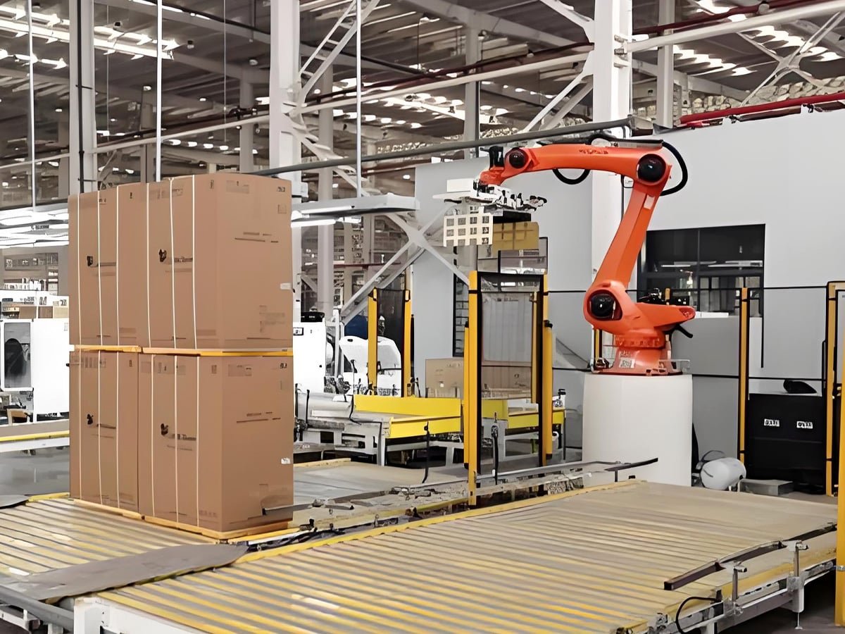 Orange industrial robot performing palletizing of stacked cardboard boxes on conveyor line in smart packaging facility, powered and controlled by Hulk cables for reliable power and data transmission in high-speed automated packaging operations